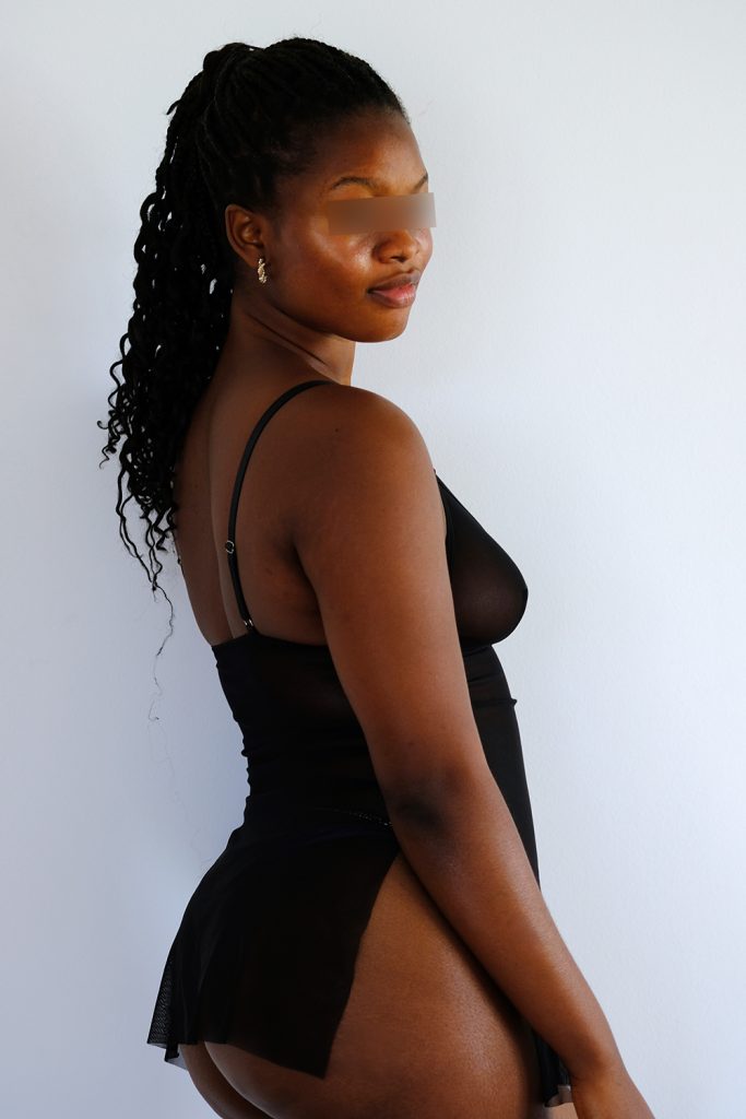 Escort Girl Olivia in schwarzen Dessous dreht sich in die Kamera