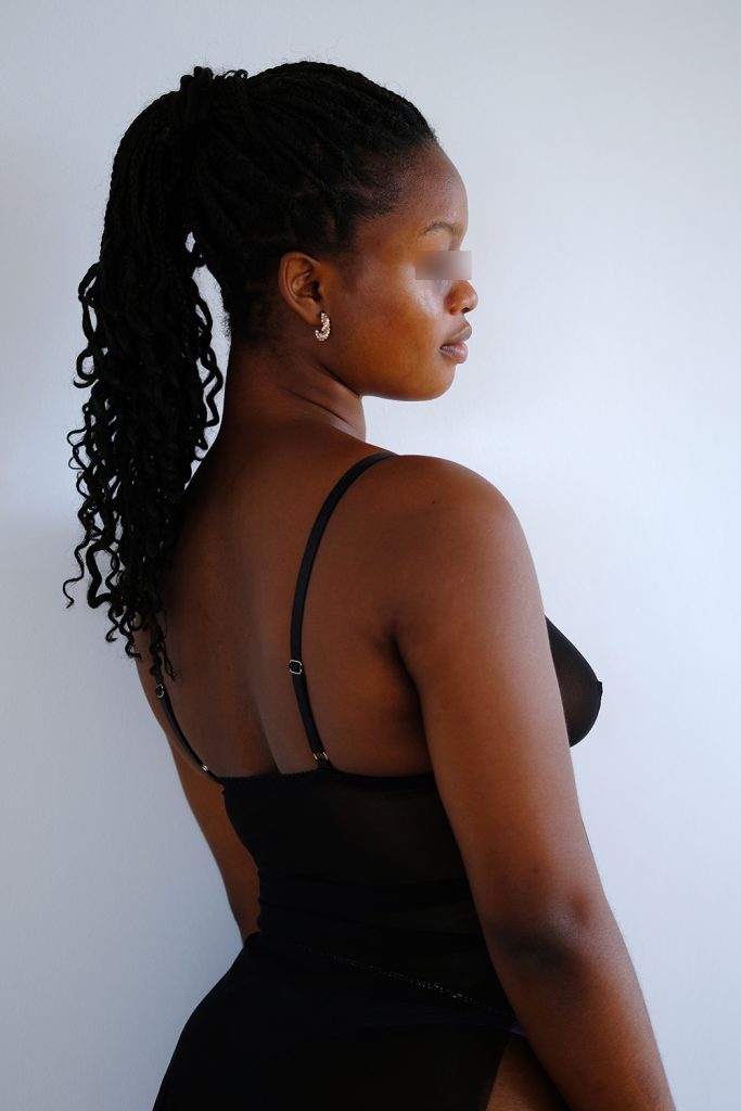 Escort Girl Olivia in schwarzen Dessous und langem Zopf